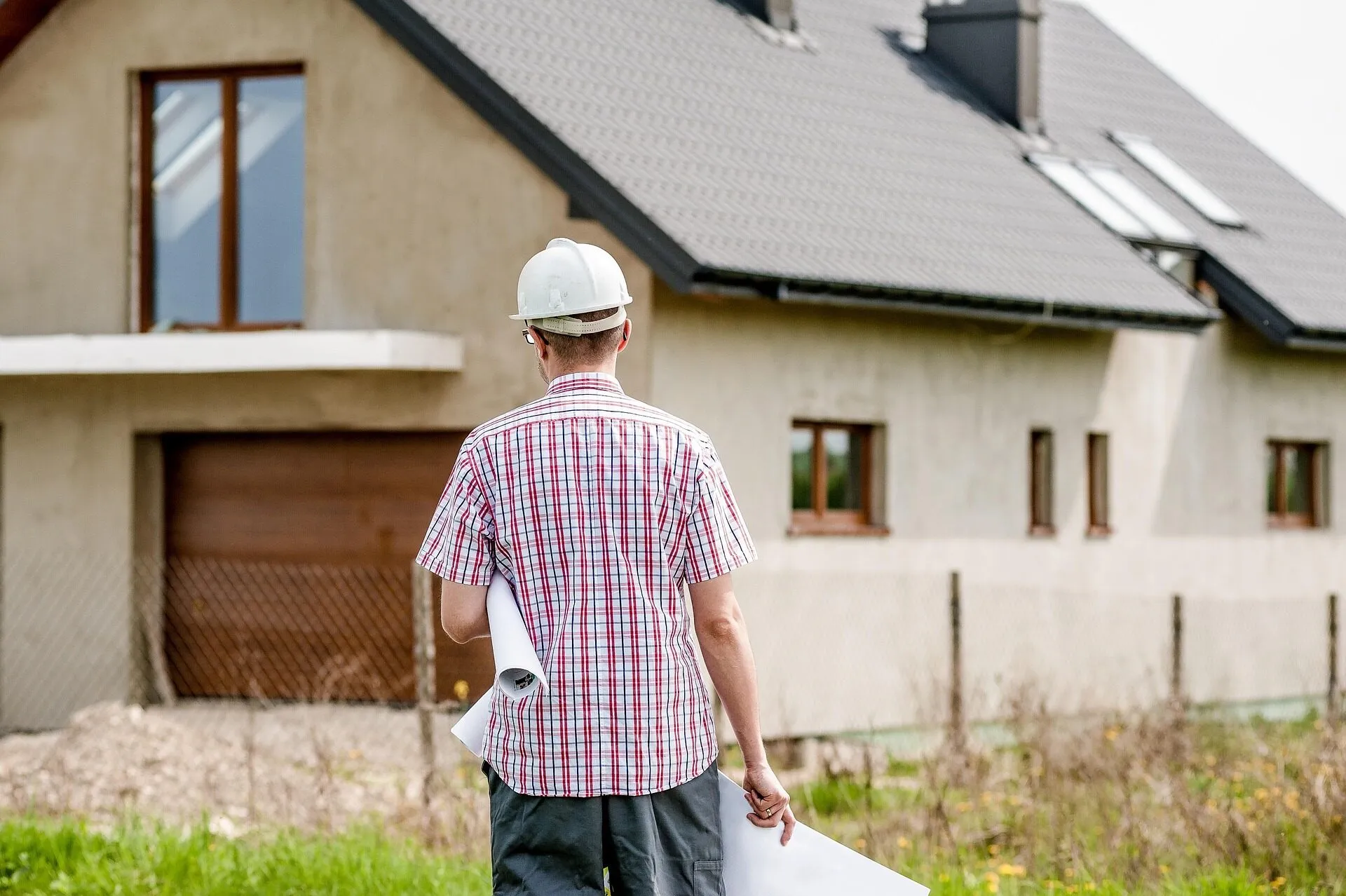 Professional builder reviewing architectural plans at a house construction site in Dublin